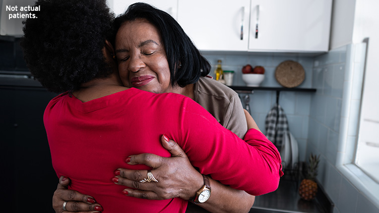 Two women hugging in a kitchen